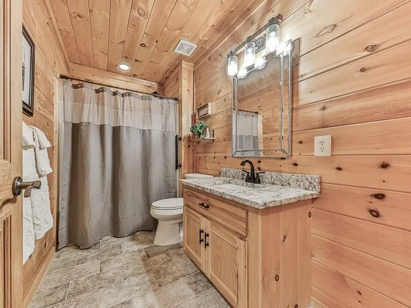 a bathroom with a granite countertop sink toilet and shower