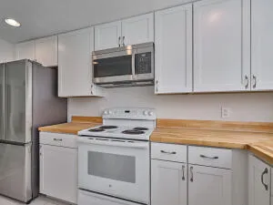 a kitchen with granite countertop white cabinets and a sink