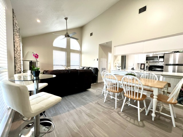 Dining area featuring wood finish floors, a ceiling fan, a high textured ceiling, and recessed lighting