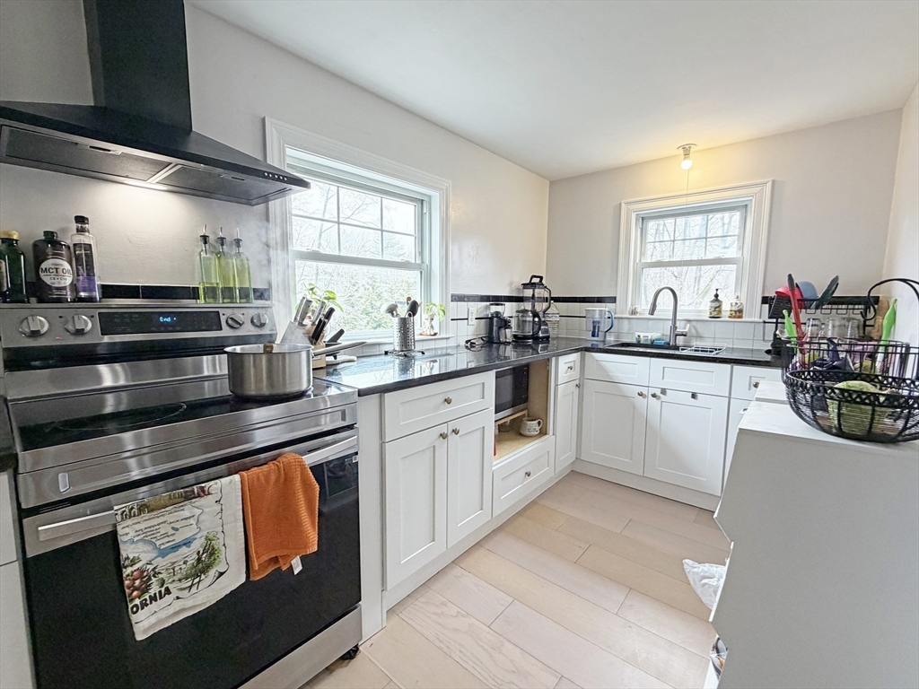 75-77 Dale Street, Unit 77 Waltham, MA 02451 - Photo 7 of 17 a kitchen with a sink stove and cabinets