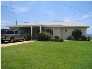 556 Blue Mountain Beach Road Santa Rosa Beach, FL 32459 - Photo 2 of 14 a front view of a house with garden