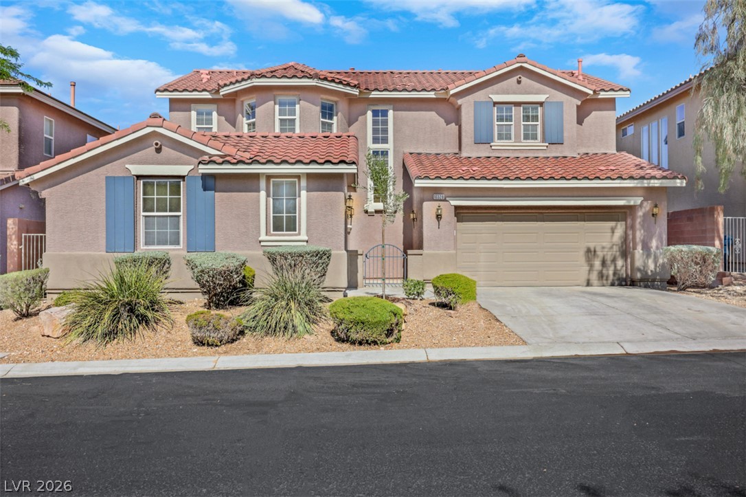 10328 Hawk Ravine Street Las Vegas, NV 89178 - Photo 2 of 55 Spanish-style facade with terracotta roof tiles and a spacious garage.
