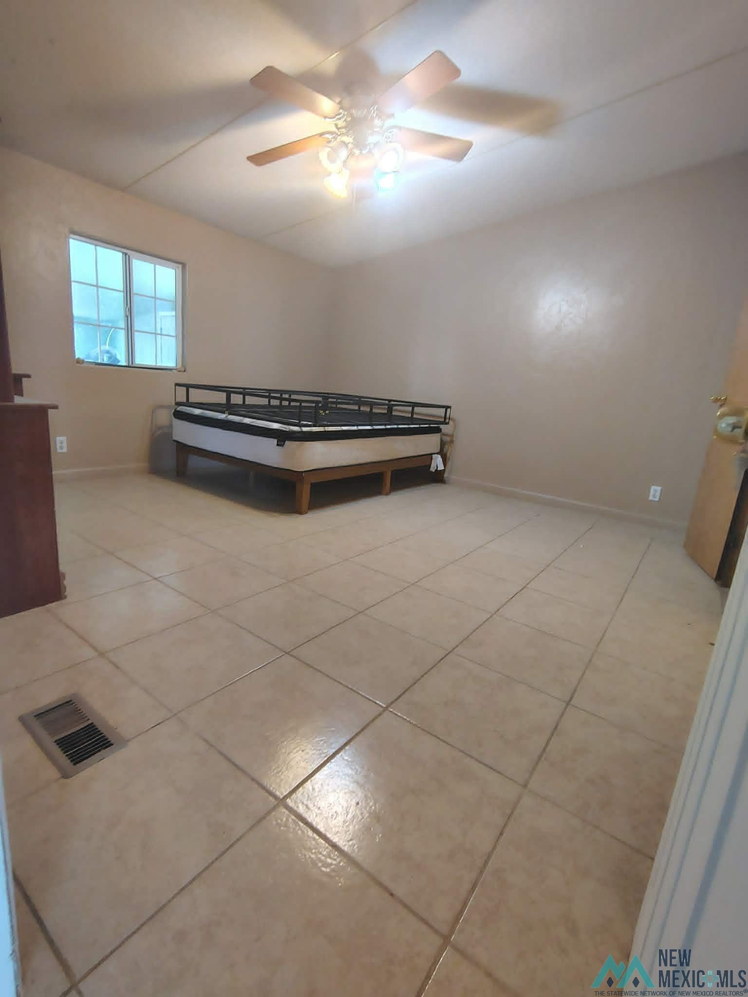 58 Fisk Road Dexter, NM 88230 - Photo 23 of 46 Spacious room with large tile flooring, a multi-pane window, and a ceiling fan with integrated lighting