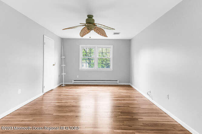 407 Cook Road Jackson, NJ 08527 - Photo 17 of 25 a view of an empty room with wooden floor and a window