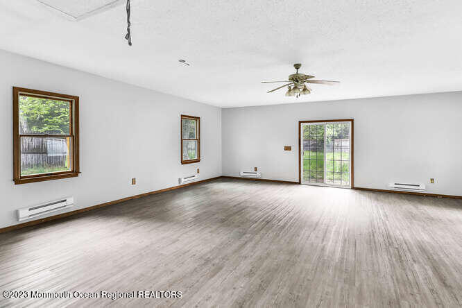 407 Cook Road Jackson, NJ 08527 - Photo 7 of 25 a view of an empty room with a window and wooden floor