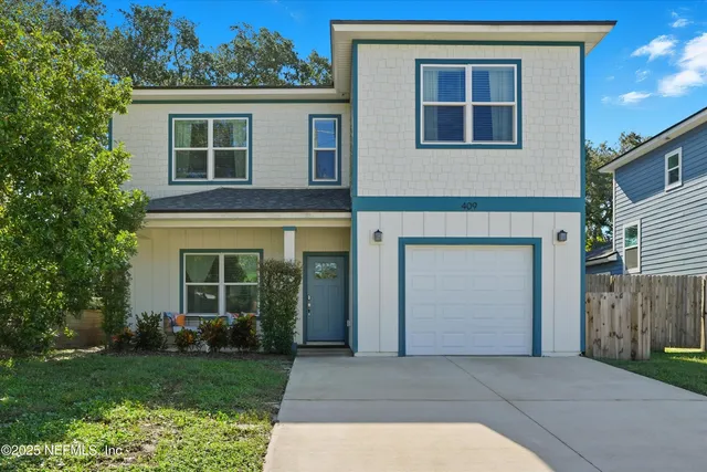 a front view of a house with a yard and garage