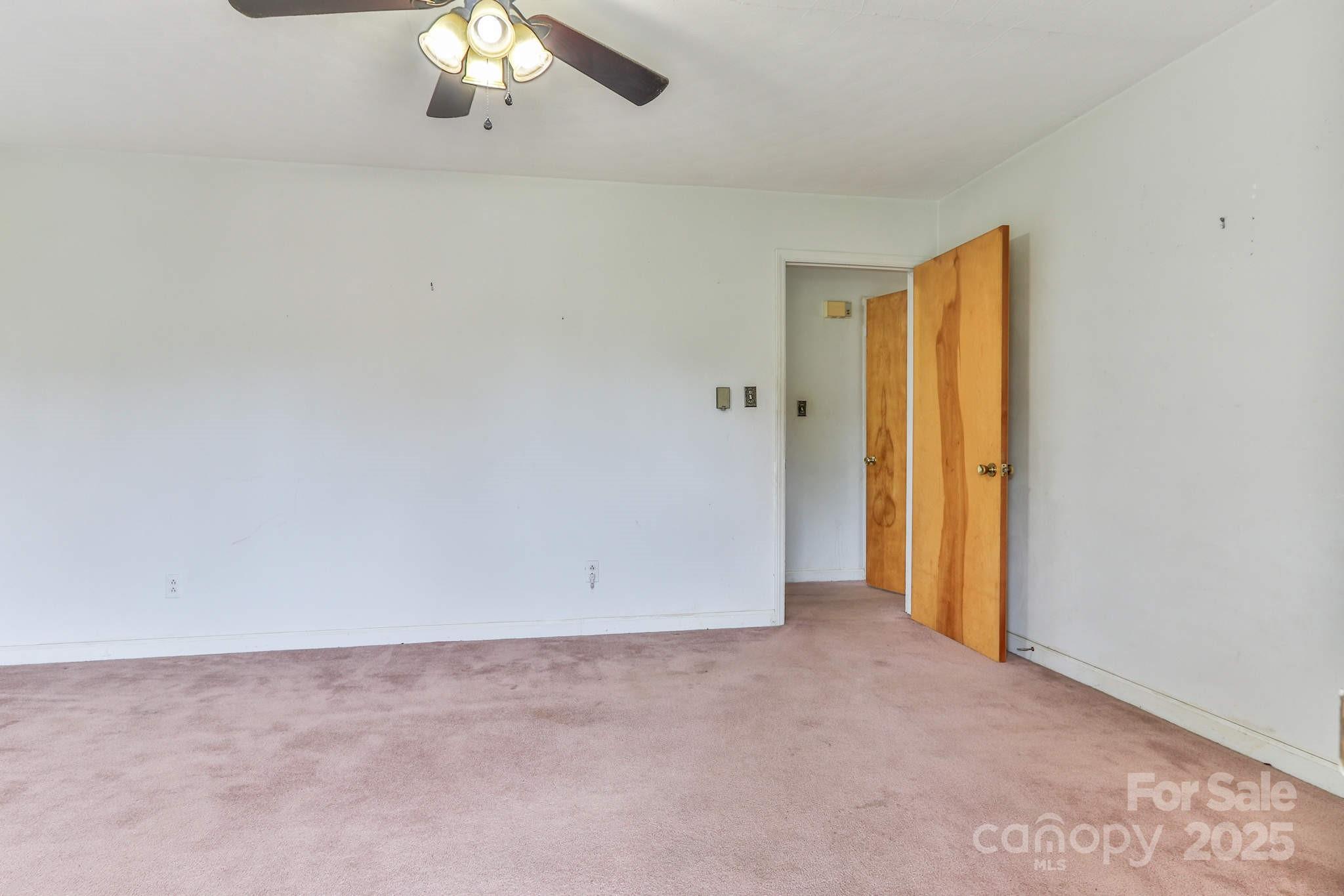 554 Wildlife Access Road Hickory, NC 28601 - Photo 12 of 34 an empty room with a chandelier fan and window