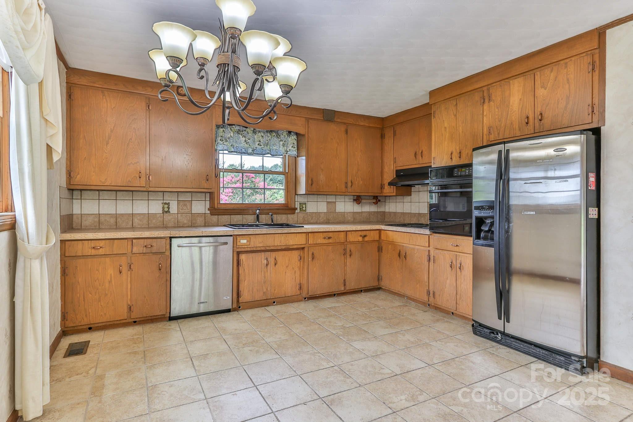 554 Wildlife Access Road Hickory, NC 28601 - Photo 7 of 34 a kitchen with cabinets a window and stainless steel appliances