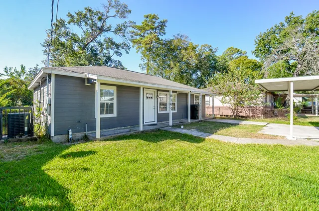 a view of a house with a yard and tree