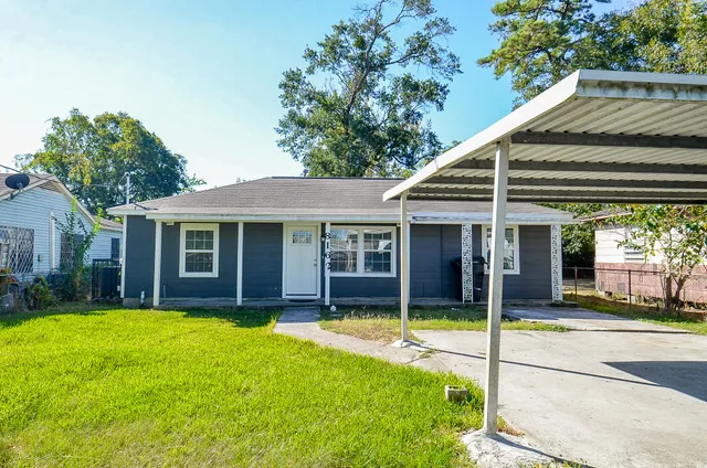 a view of a house with a yard and sitting area