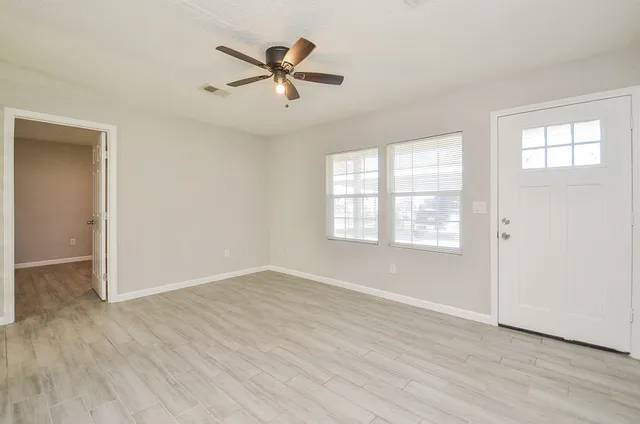 wooden floor in an empty room with a window