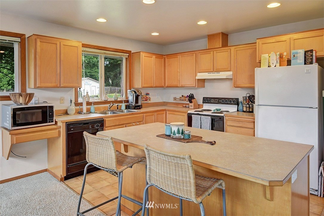 15921 179th Avenue Southeast Monroe, WA 98272 - Photo 16 of 27 a kitchen with a stove a sink a kitchen island and a refrigerator
