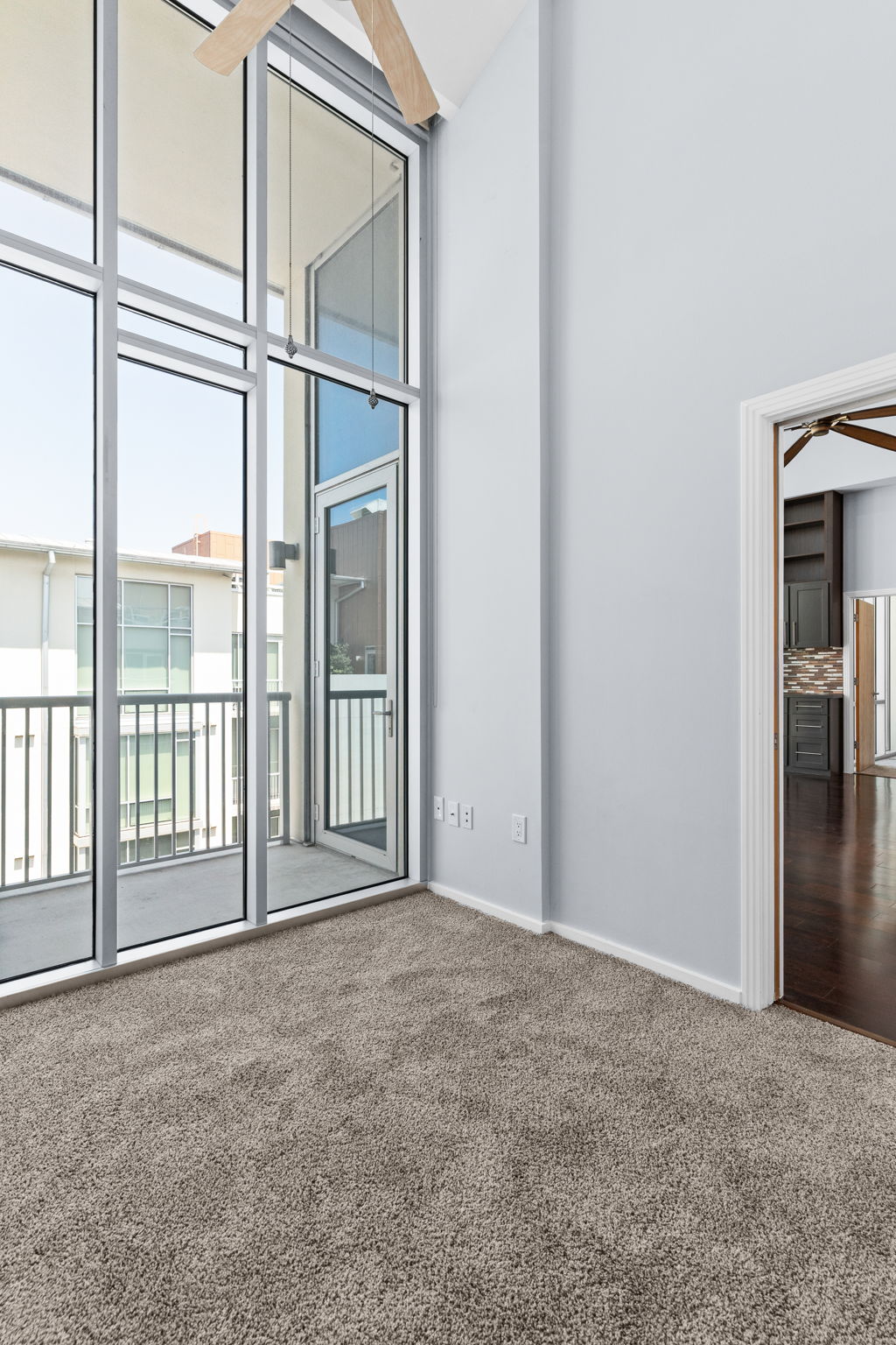 1600 Barton Springs Road, Unit 4602 Austin, TX 78704 - Photo 20 of 39 Carpeted spare room with a ceiling fan, a towering ceiling, and expansive windows