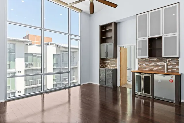 a kitchen with stainless steel appliances granite countertop a refrigerator a stove and a sink with wooden floor