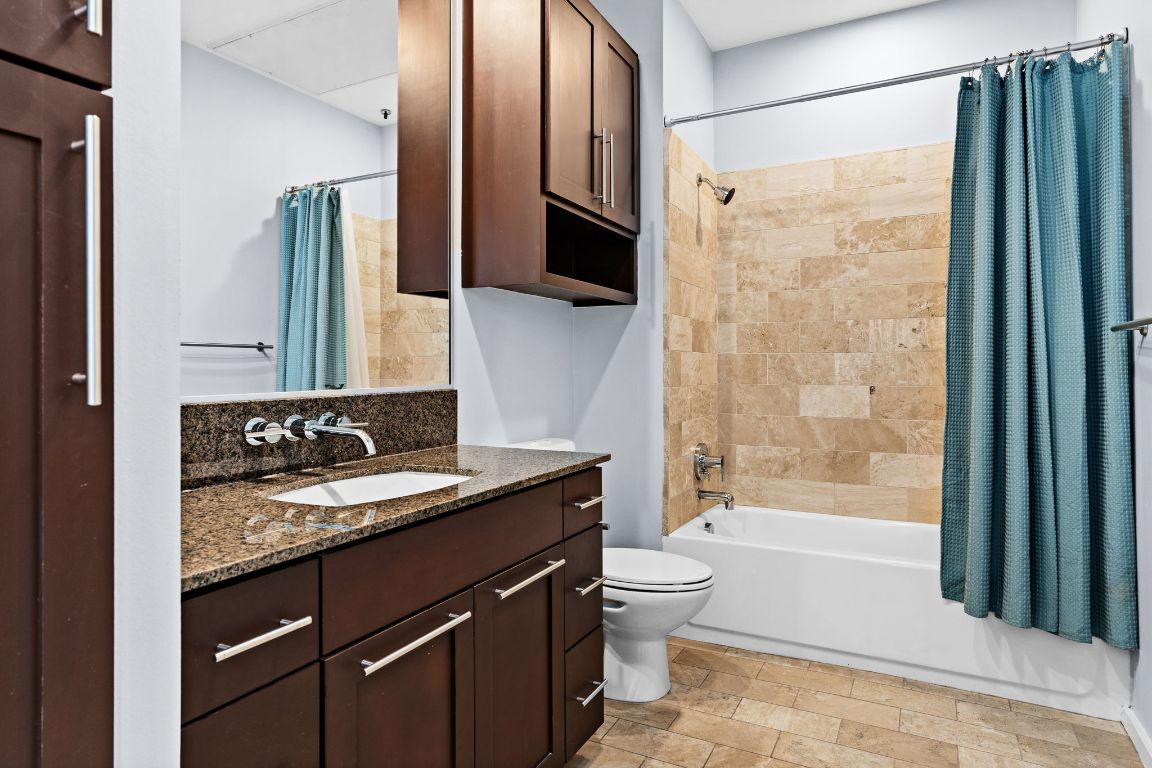 1600 Barton Springs Road, Unit 4602 Austin, TX 78704 - Photo 10 of 39 a bathroom with a granite countertop sink toilet and shower
