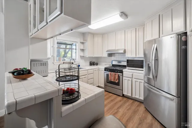 a kitchen with granite countertop white cabinets and white appliances