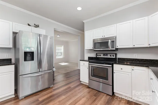 a kitchen with stainless steel appliances a white cabinets and a stove top oven