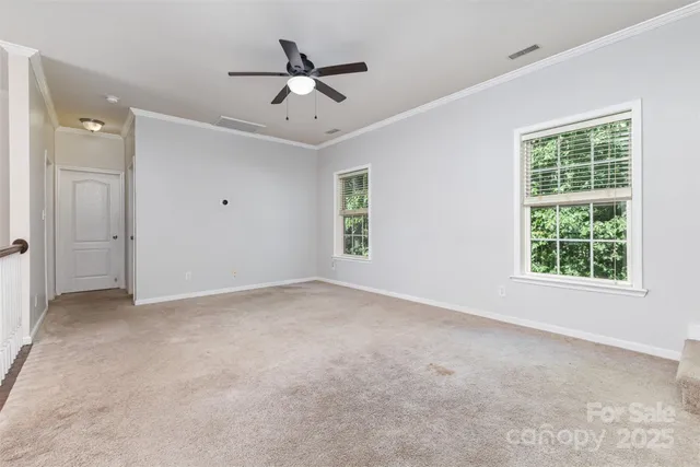 an empty room with windows and fan