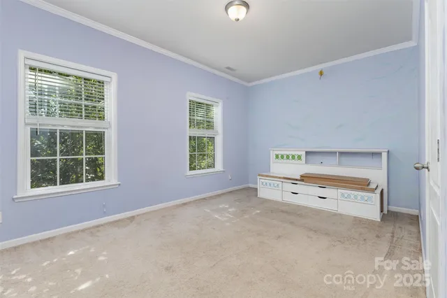 an empty room with a dresser and a window