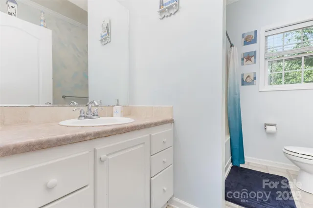 a bathroom with a granite countertop sink a toilet and a mirror