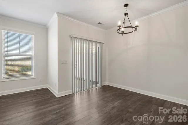 a view of empty room with wooden floor and windows