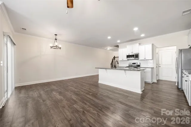 a view of kitchen with refrigerator microwave and wooden floor