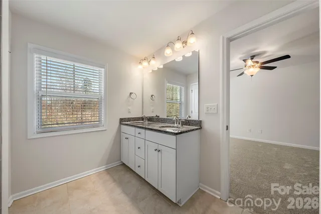 a bathroom with a granite countertop sink a large mirror and a shower