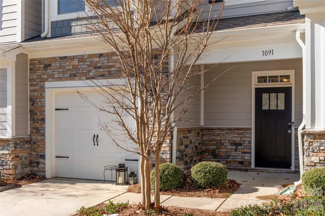 a front view of a house with plants