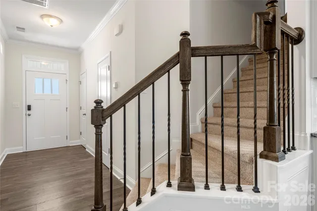 a view of staircase with railing and white walls
