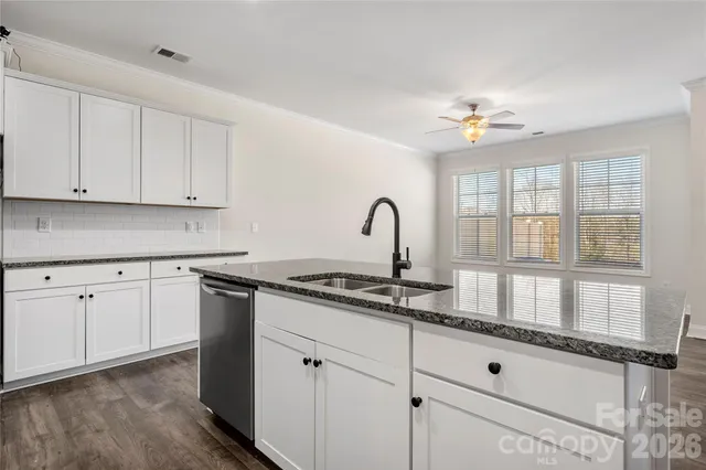 a kitchen with granite countertop white cabinets and appliances