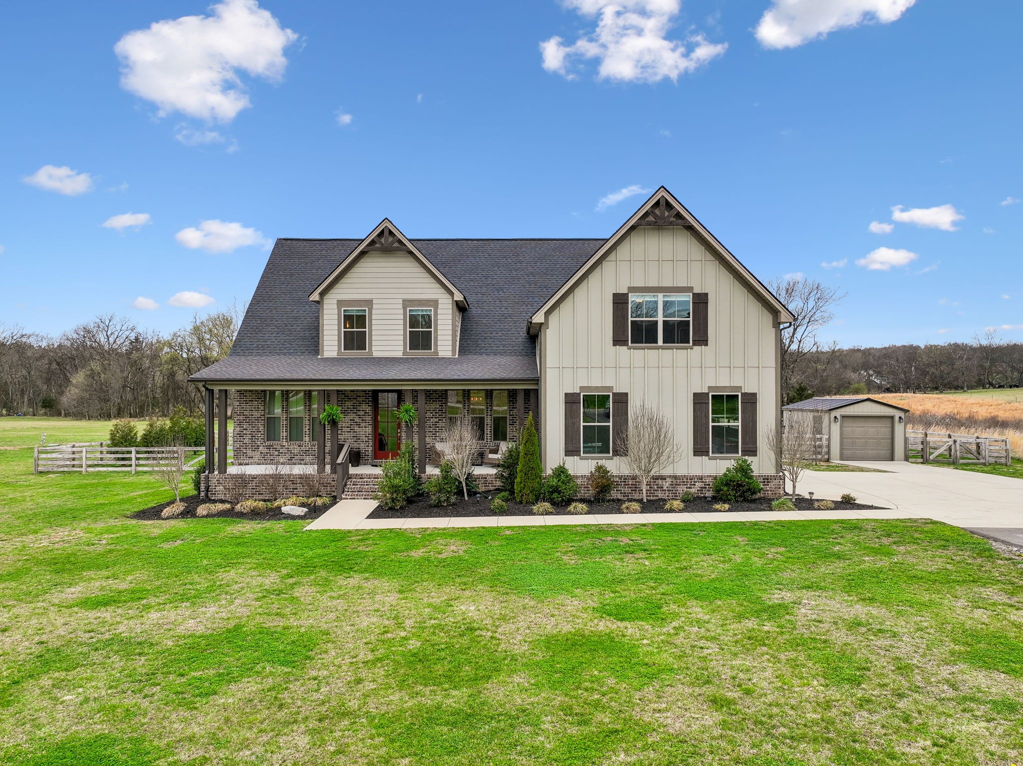 a front view of a house with garden and trees