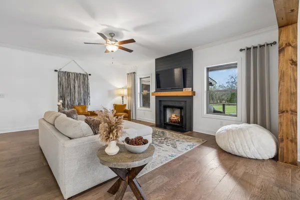 a living room with furniture a flat screen tv and a fireplace
