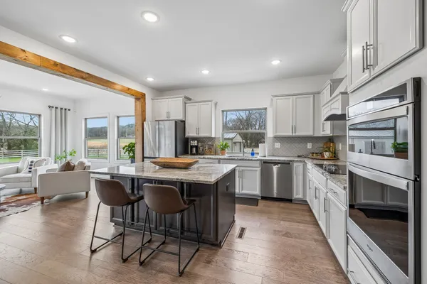 a stove top oven sitting inside of a kitchen and stainless steel appliances