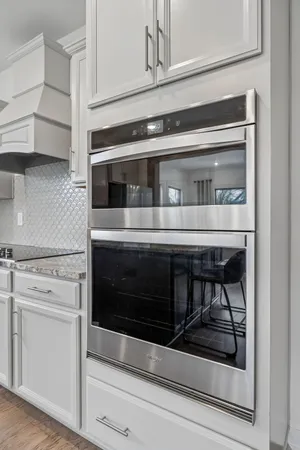 a kitchen with granite countertop white cabinets and white appliances