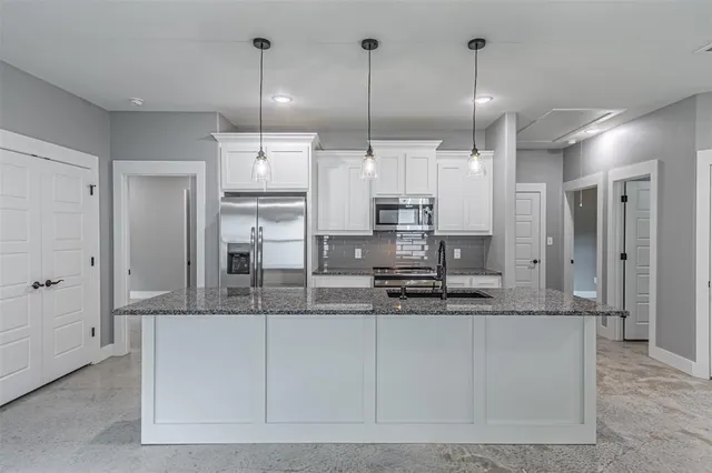 a large kitchen with kitchen island a sink stainless steel appliances and cabinets