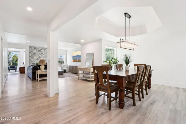a view of a dining room and livingroom with furniture wooden floor a chandelier