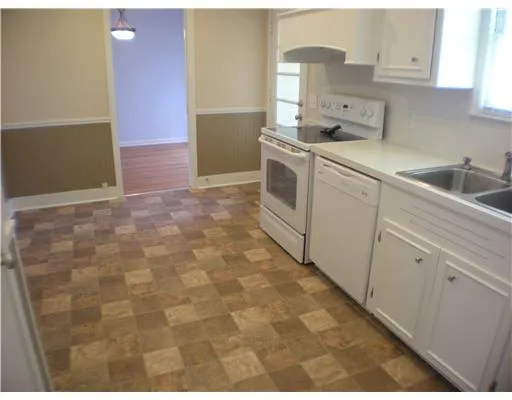 a kitchen with a sink a stove and cabinets