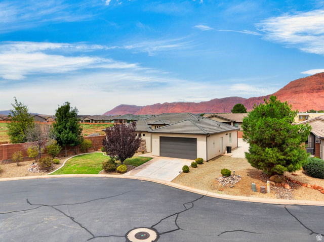 11 East 640 South Ivins, UT 84738 - Photo 2 of 44 Single-story residence featuring a two-car garage, concrete driveway, and a stone-tiled roof