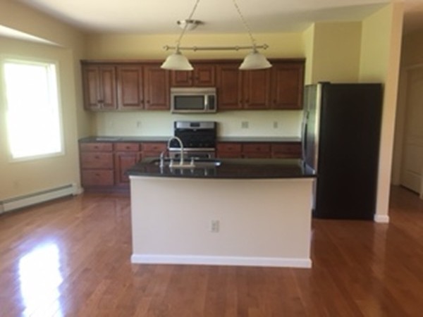 10 Gunn Road Montague, MA 01351 - Photo 11 of 26 a kitchen with kitchen island granite countertop wooden cabinets a refrigerator and a sink