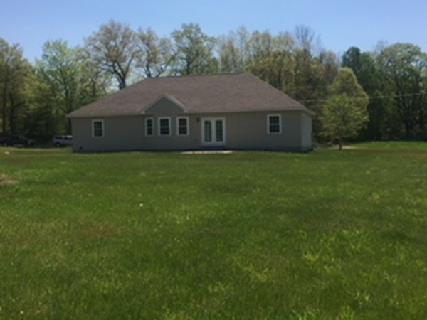 10 Gunn Road Montague, MA 01351 - Photo 6 of 26 a house that is sitting in the grass with large trees and plants