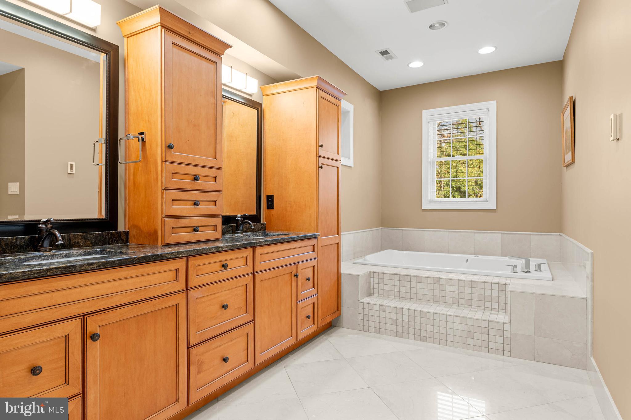 1311 Hagys Ford Road Penn Valley, PA 19072 - Photo 38 of 80 a spacious bathroom with a double vanity sink a mirror and a bathtub