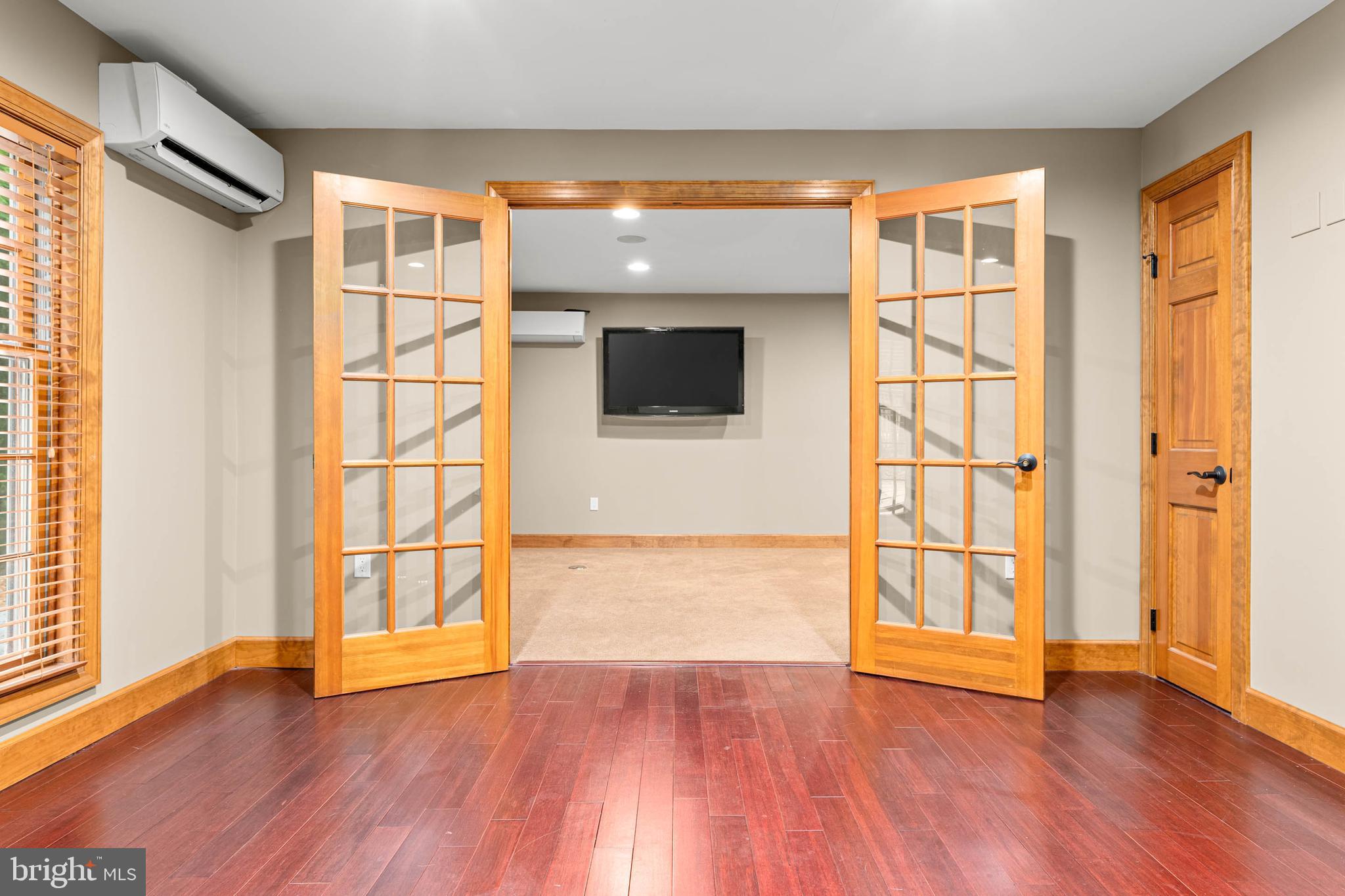 1311 Hagys Ford Road Penn Valley, PA 19072 - Photo 66 of 80 an empty room with wooden floor and windows with curtains