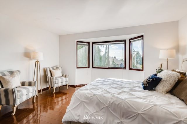 a large bedroom with a bed and wooden floor