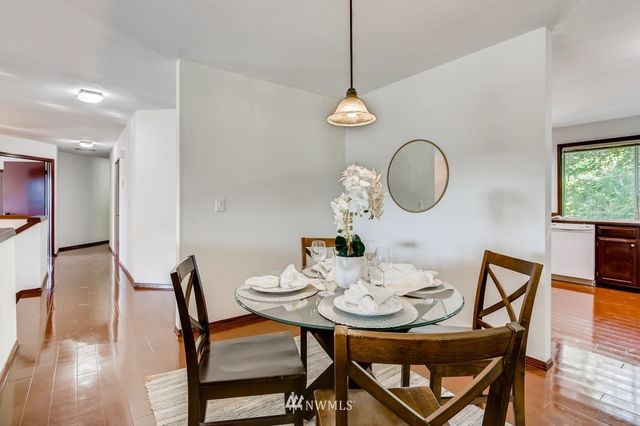 a view of a dining room and livingroom with furniture wooden floor a chandelier