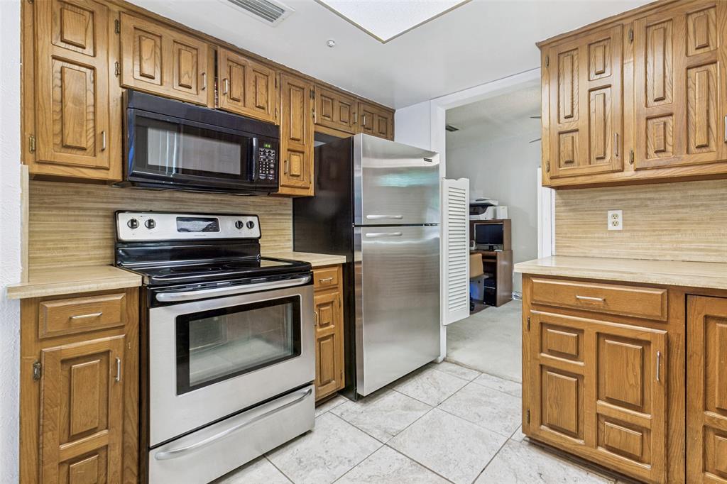 44 Merrie Circle Richardson, TX 75081 - Photo 13 of 30 a kitchen with stainless steel appliances granite countertop a refrigerator stove and cabinets