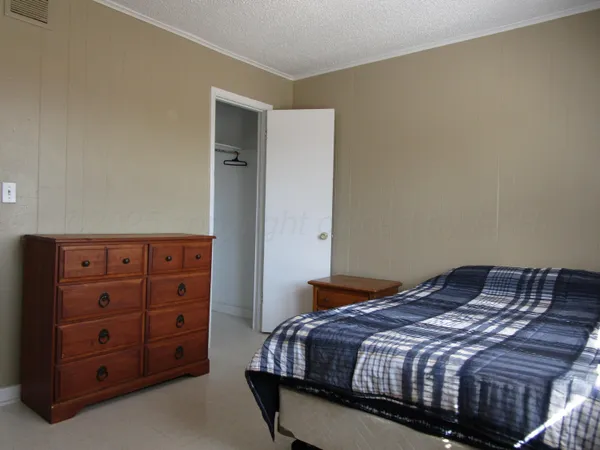 a bedroom with a bed and a dresser