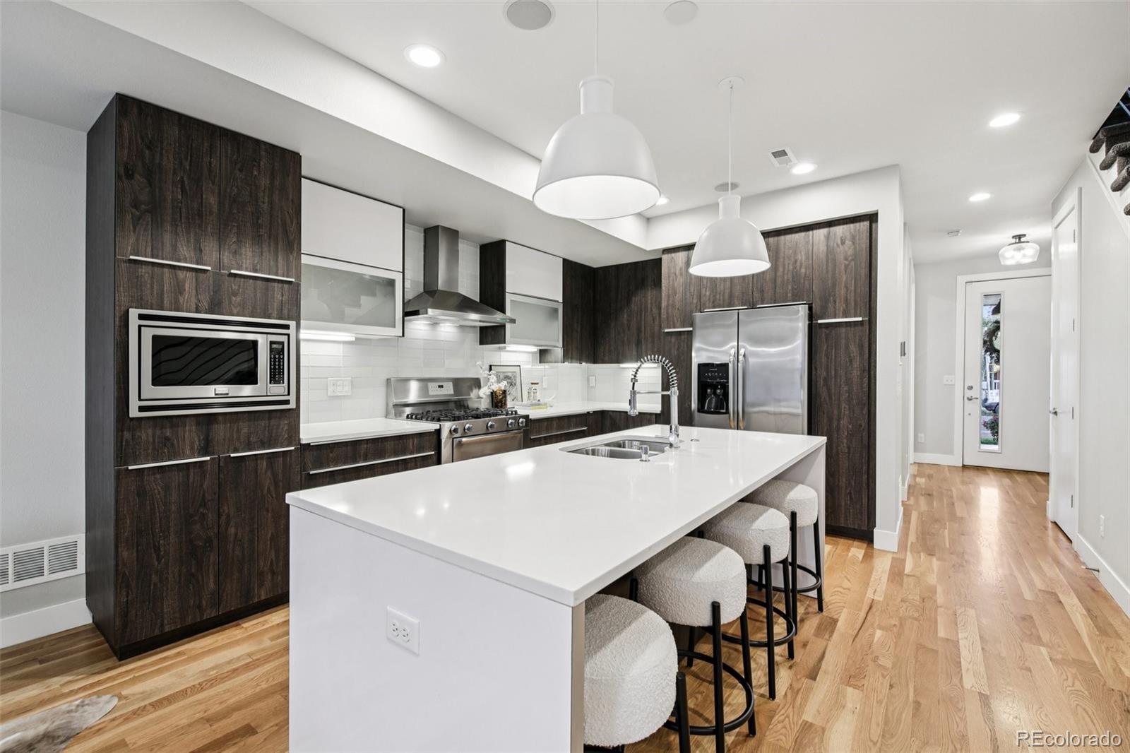 2825 Stout Street Denver, CO 80205 - Photo 13 of 42 a kitchen with stainless steel appliances a refrigerator and a stove top oven