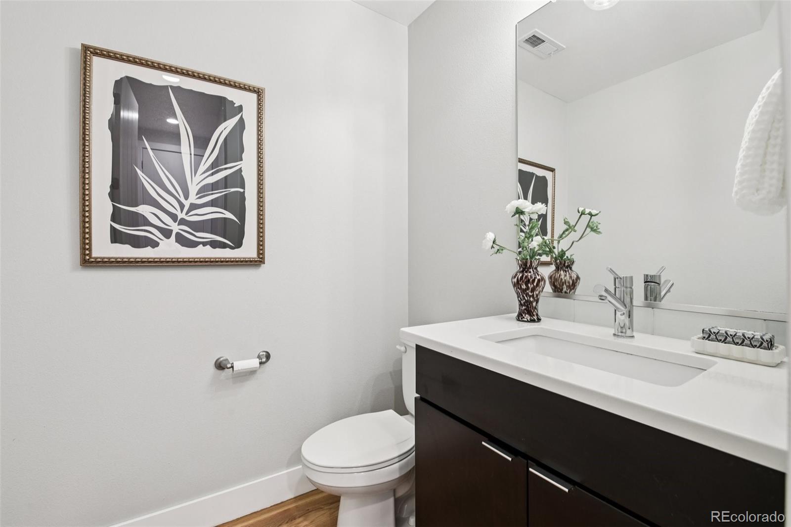 2825 Stout Street Denver, CO 80205 - Photo 14 of 42 a bathroom with a sink vanity and toilet