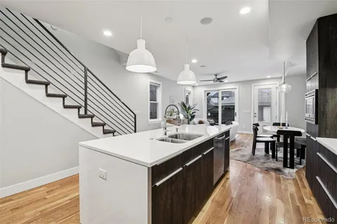a kitchen with stainless steel appliances a sink stove and wooden floor