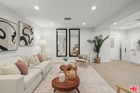 a living room with furniture potted plant and a large window